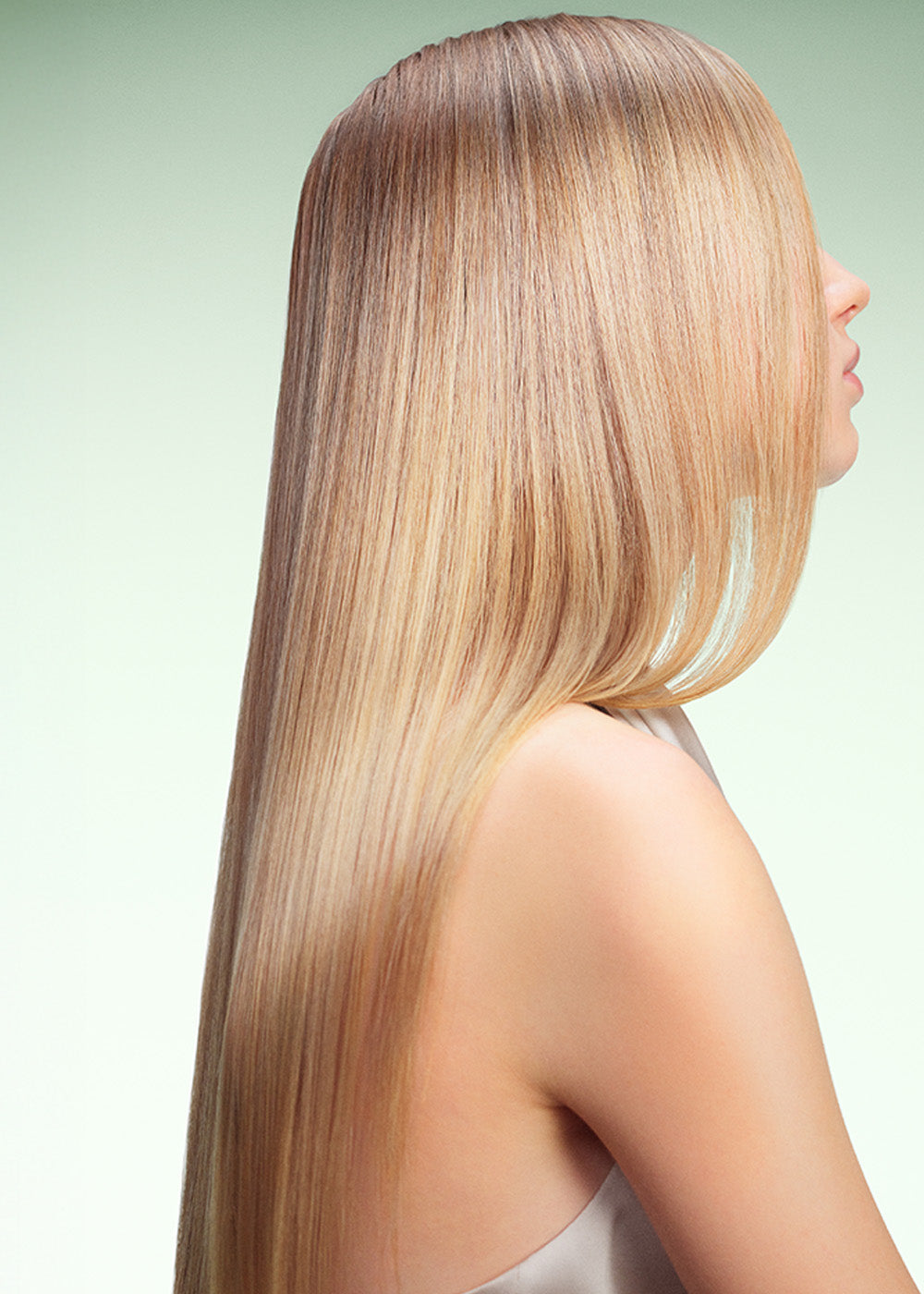 Model with glossy, long blonde hair on green background